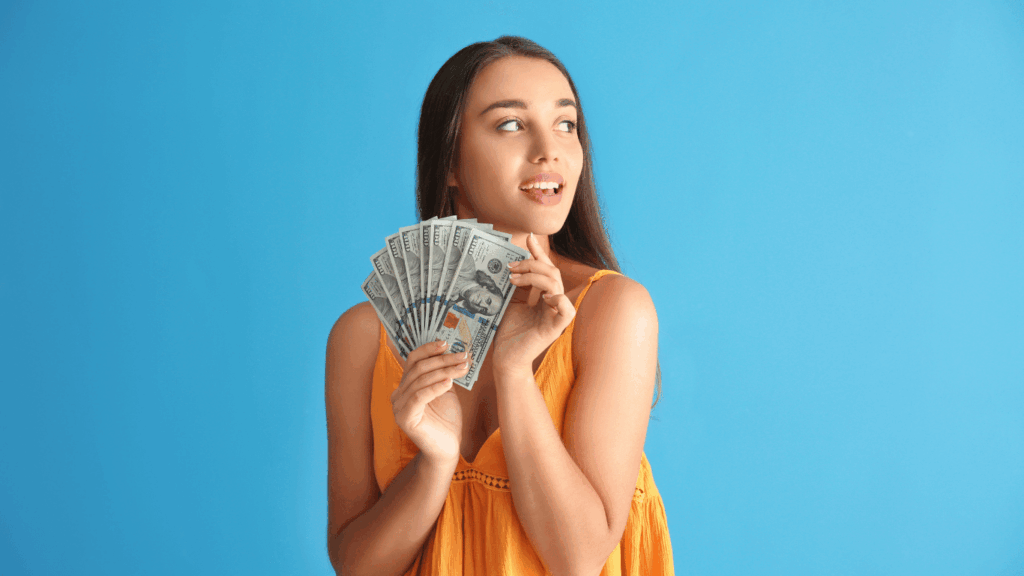 Mujer sosteniendo dólares estadounidenses, ilustrando el uso del dólar blue como una alternativa a la cotización oficial.