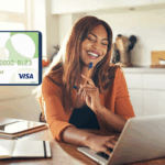 Mujer sonriente trabajando en su laptop con una tarjeta de crédito de Banco Comafi visible en la parte superior izquierda.