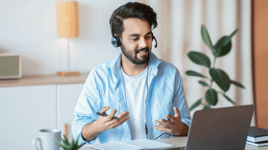 Un profesor con auriculares laburando en su notebook, una de las formas de generar ingresos extra en Argentina desde tu casa.