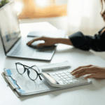 Persona organizando sus finanzas y consultando una guía completa sobre el Monotributo en Argentina en su notebook, con calculadora y papeles sobre el escritorio.